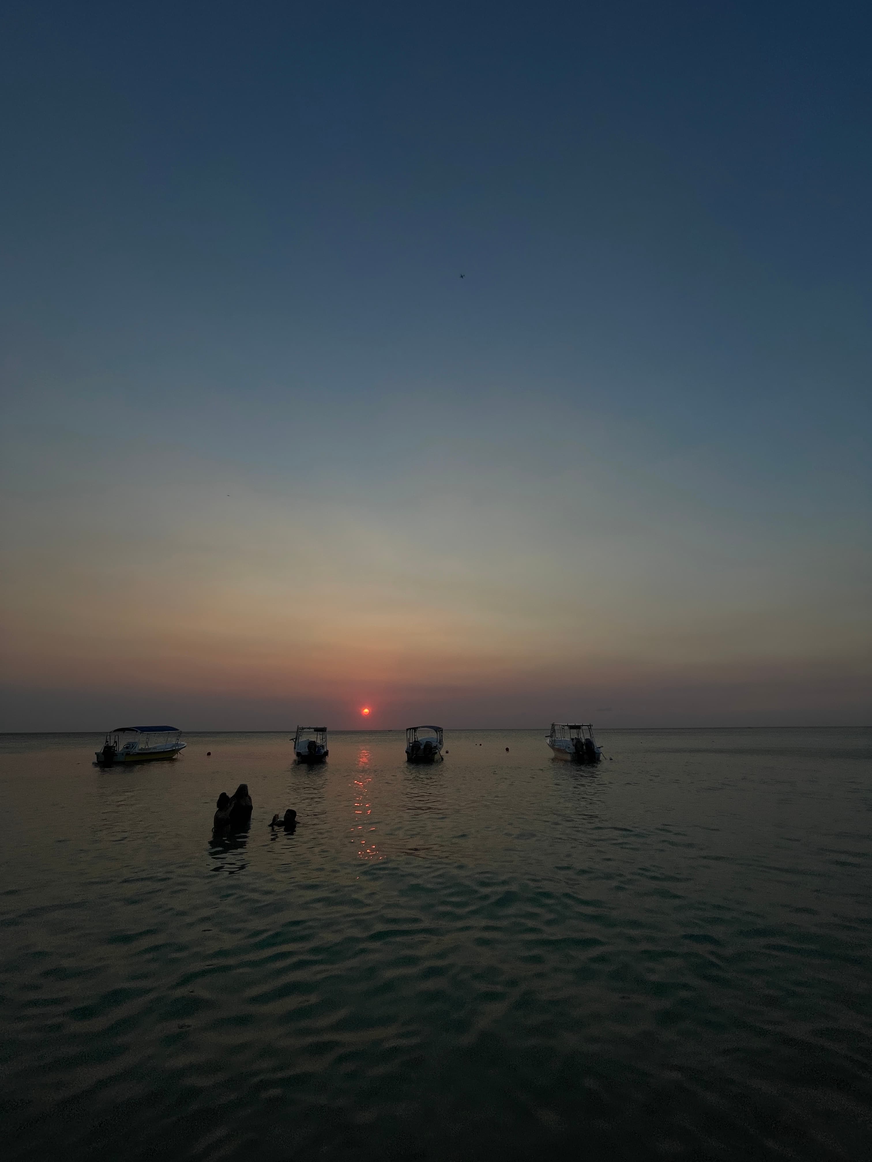 Fleet of boats at anchor during sunset